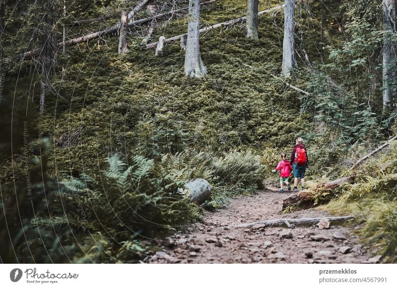 Family trip close to nature. Mother with little girl walking on path in forest family vacation summer hike travel journey kid outdoors recreation hiking active