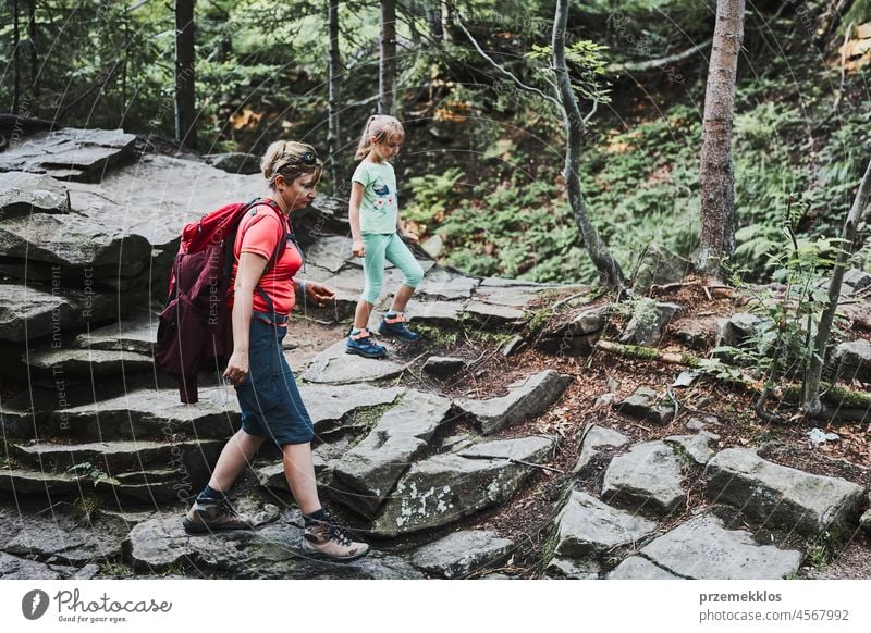 Family trip in mountains. Mother with little girl walking on mountain path family vacation summer hike travel journey forest kid outdoors recreation hiking