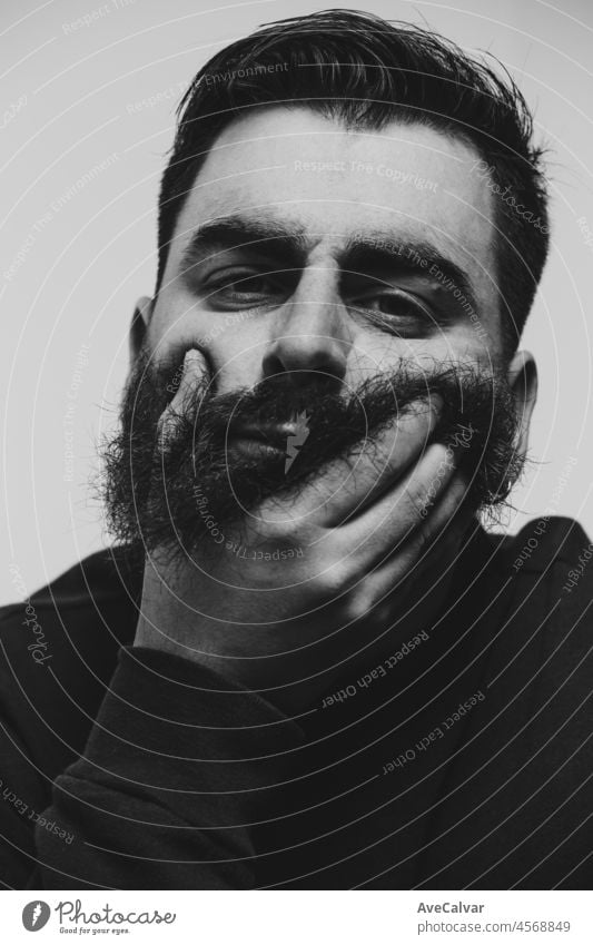 Black and white image of a bearded man looking serious straight to camera. Male handsome portrait. person fit standing face hair lifestyle background dressed