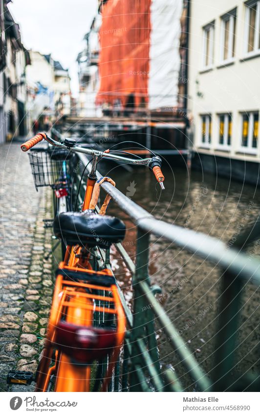 Orange bike on the railing Town Exterior shot Iron Still Life luggage carrier cyclists Shallow depth of field Mobility concept Fence Day Bicycle Stone Amsterdam
