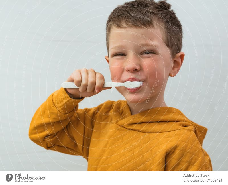 Boy brushing teeth in bathroom kid boy toothbrush smile portrait looking at camera hygiene everyday happy routine daily oral personal domestic care morning home
