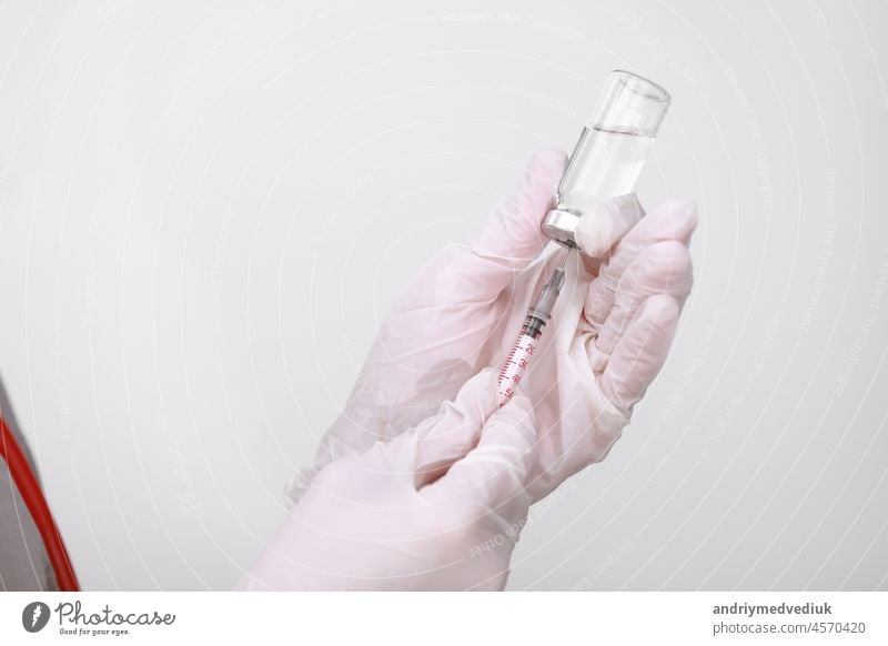 Doctor, nurse or scientist hand in white medical gloves holding flu, measles, coronavirus vaccine shot for diseases outbreak vaccination, medicine and drug concept