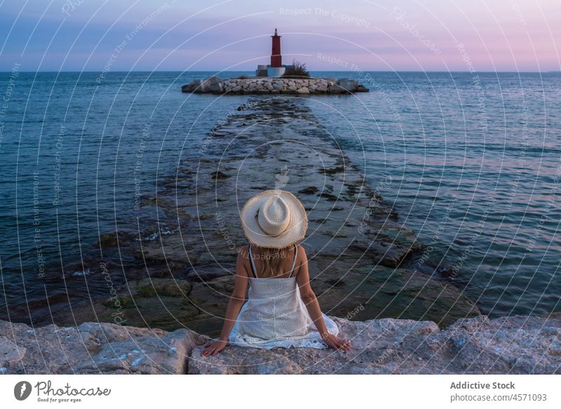 Anonymous woman enjoying view of lighthouse in sea travel observe trip beacon water navigate journey path nature marine guide seawater villajoyosa spain stone