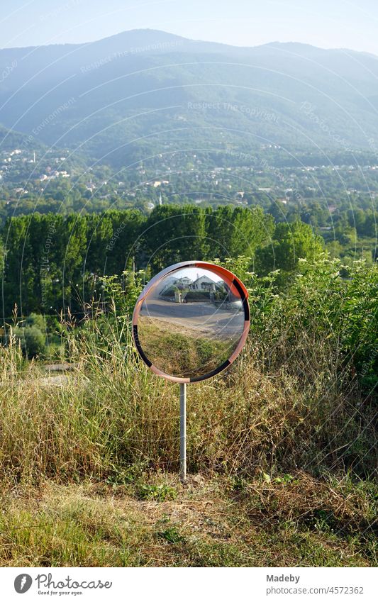 Round mirror in the mountain landscape in summer sunshine for car traffic at Kocaeli Kartepe at Sapanca Gölü in Sakarya Province, Turkey Mirror traffic mirrors
