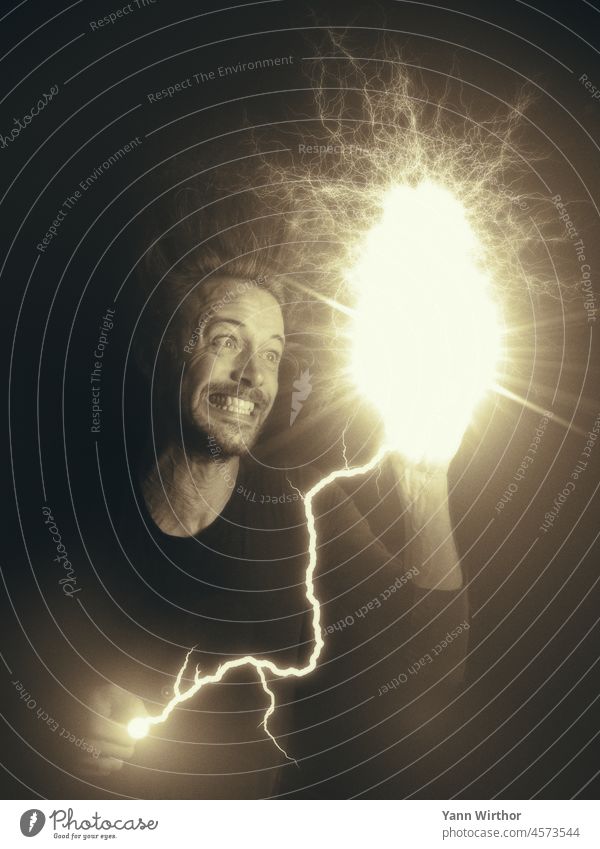 Man with tense facial expression holding lightning bolt causing electrical discharge in other hand Electrocution portrait Electricity Lightning rod Electrickery