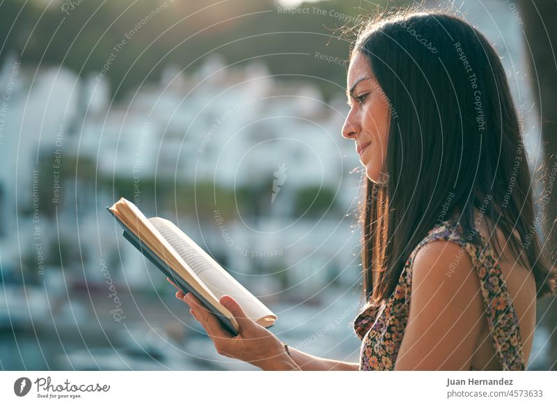 young woman reading a book at sunset on her terrace pretty relax relaxation education outside alone learning literature student one person horizontal copyspace