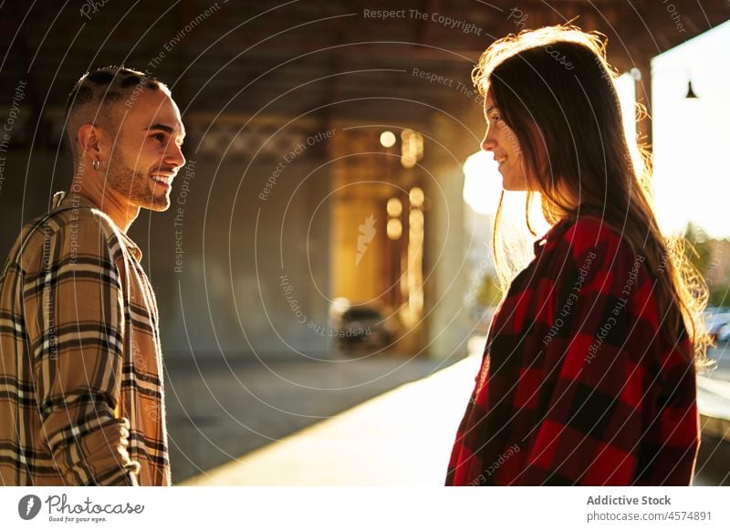 Young smiling friends standing under bridge at sunshine woman expressive meeting carefree friendship sunset cool millennial female sundown pleasant positive