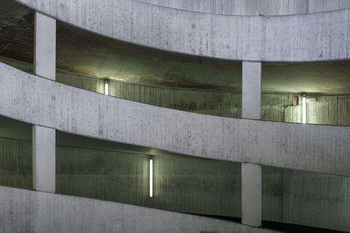 Interior view driveway parking garage in exposed concrete aesthetics Architecture Concrete Parking garage Trashy urban Old Neon light shabby Gray