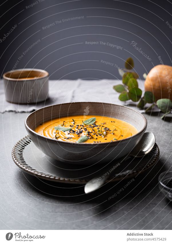 Tasty pumpkin soup placed on a plate on a table on a tabletop bowl delicious vegetable gourmet tasty cuisine food yummy spoon serve healthy food nutrition