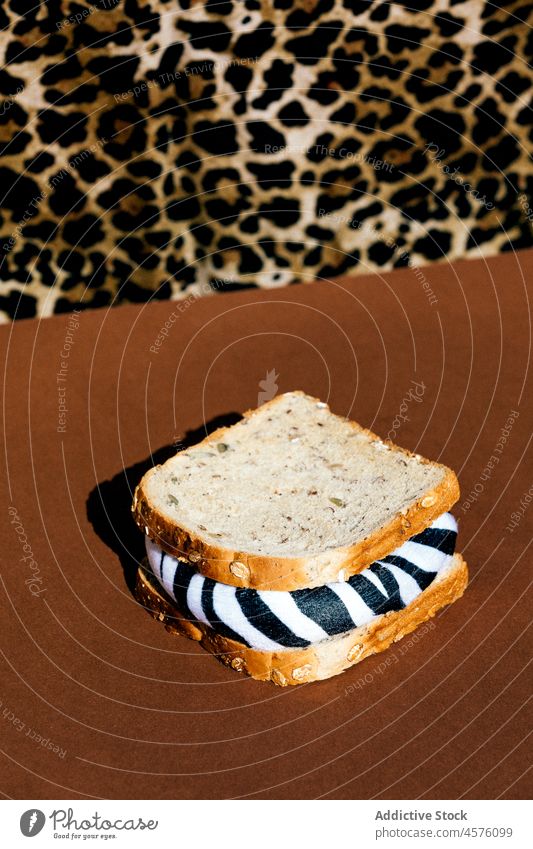 Faceless person near sandwich with zebra filling animal harmful ecology unfriendly exterminate problem annihilation food light portion product bread creative