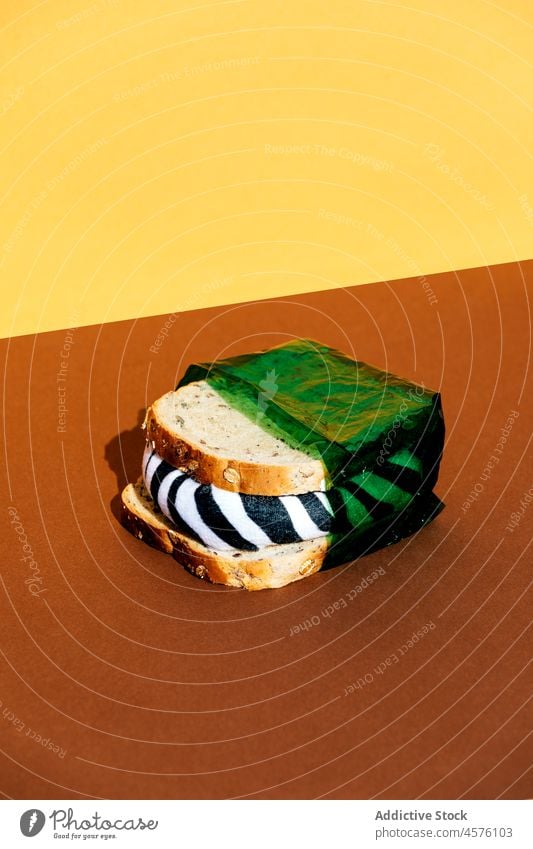 Sandwich in green plastic wrap sandwich pollute zebra animal harmful ecology unfriendly exterminate food light portion fill wall product bread package