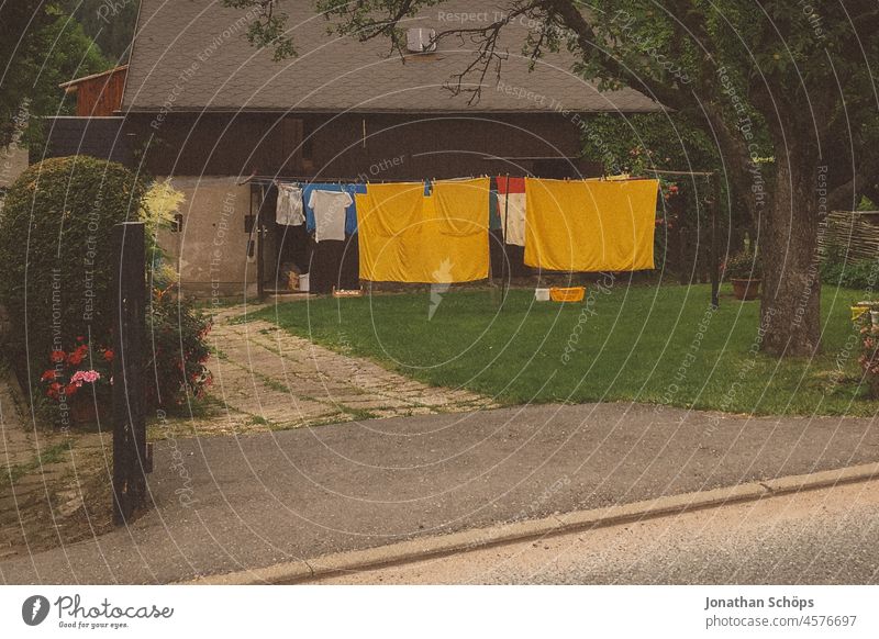 Clothesline with yellow laundry in front yard clothesline Yellow Laundry Garden House (Residential Structure) Front garden Footpath Sidewalk