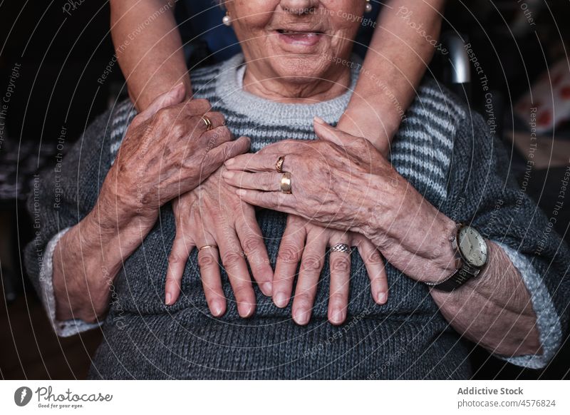 Anonymous nurse hugging aged woman in room elderly patient help care support disable pensioner old specialist home apartment retire embrace tender grandmother