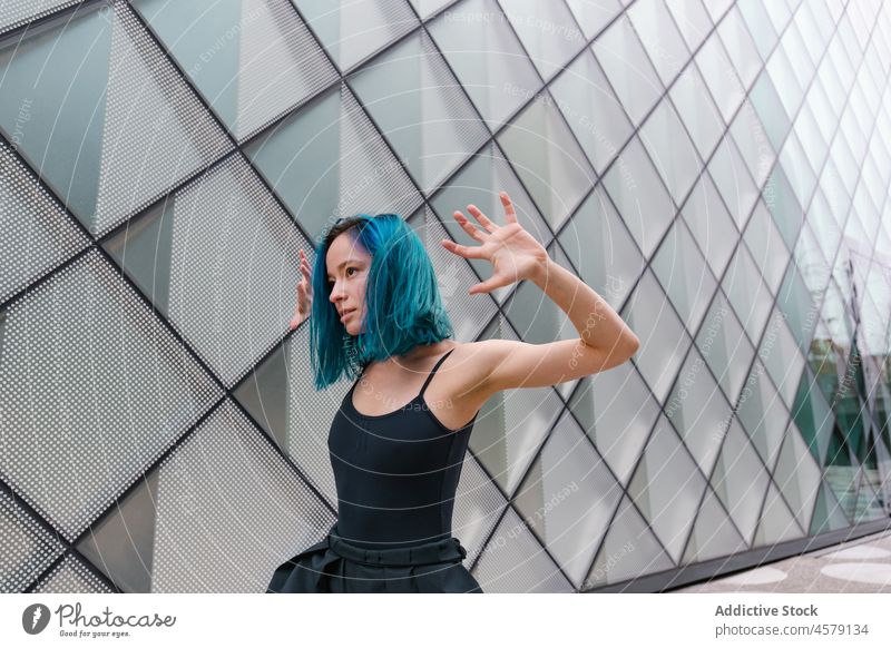 Confident female performing dance near wall of modern building woman hobby choreography portrait charming arms raised dancer appearance trendy style street glad