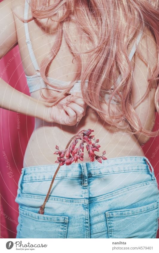 Body image of a real young woman wearing jeans and holding a exotic flower body positive pink femininity female hair bra underwear fashion trendy concept