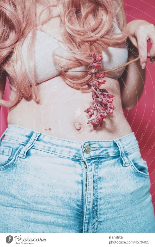 Body image of a real young woman wearing jeans and holding a exotic flower body positive pink femininity female hair bra underwear fashion trendy concept