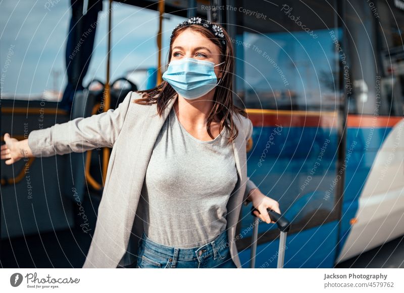 Young woman in protective mask traveling in the bus passenger exit leave transportation luggage baggage portugal faro protection happy businesswoman covid-19