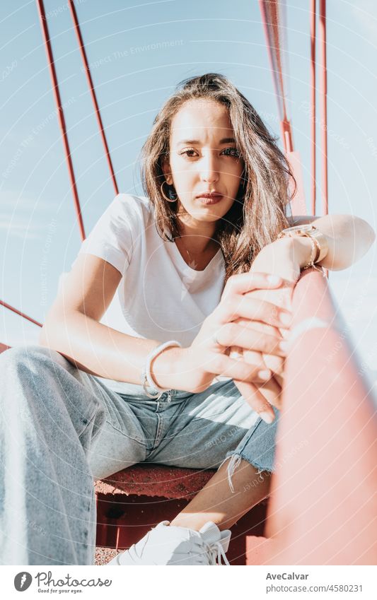 Cool hipster african young girl with curly hair, street hip hop style, looking serious defiant to camera, dynamics and expression. Copy space, social network concept. White tshirt denim jeans