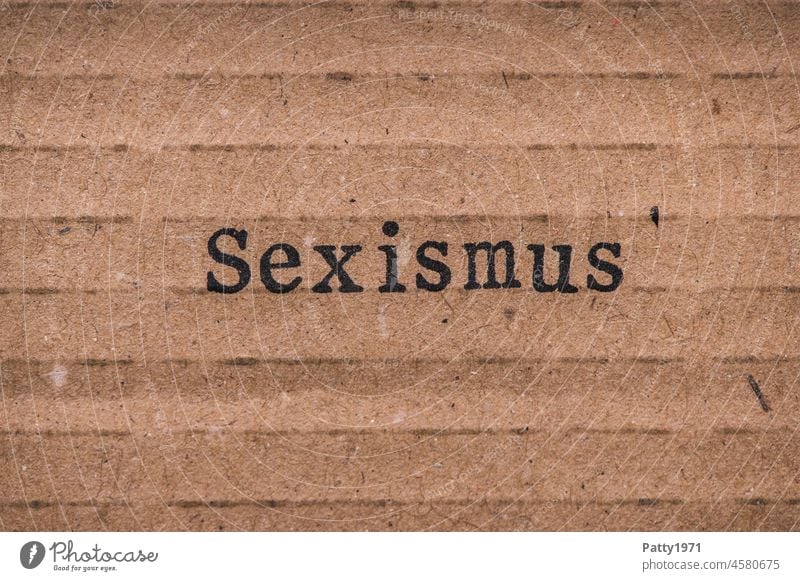 Stamped text on cardboard. Sexism. misogyny discrimination Cardboard paperboard Hatred Woman Paper Old Grunge Brown Text Design Deserted