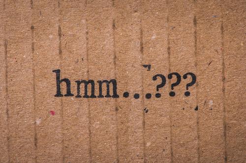 Stamped text on cardboard. hmm...??? Question mark question Perplexed indecisiveness Cardboard paperboard Paper Old Grunge Brown Text Characters Irritation