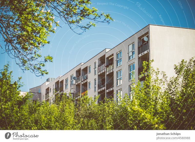 modern apartment block behind green bushes and trees Tree Green Summer block of flats dwell living environment Rent Apartment Building Apartment house Idyll