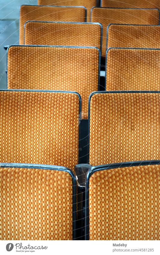 Old cinema chairs and rows of seats upholstered in fabric in the style and colours of the seventies in an old factory hall with antiques in the Margaretenhütte district of Gießen an der Lahn in Hesse
