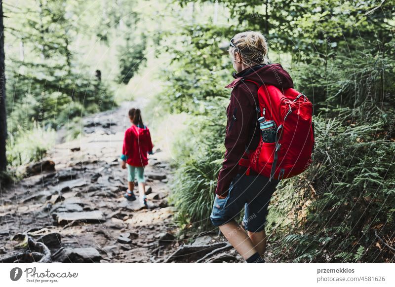 Family trip in mountains. Mother with little girl walking on path in forest family vacation summer hike travel journey kid outdoors recreation hiking active
