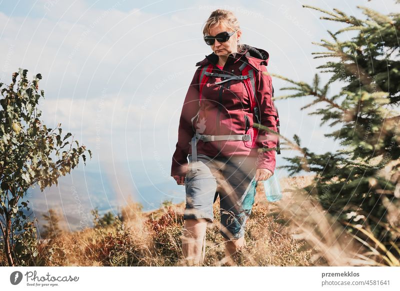 Woman with backpack hiking in mountains, spending summer vacation close to nature adventure trip travel trekking woman active journey wanderlust tourist