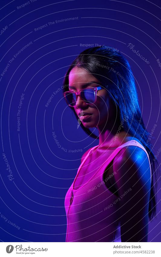Stylish Brazilian woman in studio with fluorescent light style sunglasses accessory cool trendy ultraviolet modern fashion portrait female brazilian appearance