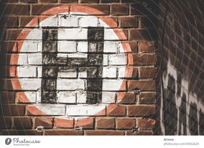 Here's a H symbol Circle sign Painted traffic signs street sign signage Hold Stop mark Brick building brick wall Facade Factory Factory facade Black White Red