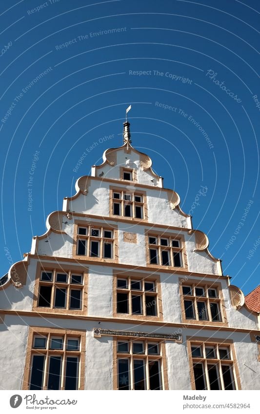 Artful gable of a restored old merchant's house in front of a bright blue sky in summer sunshine in the old town of the old hanseatic city of Lemgo near Detmold in East Westphalia-Lippe