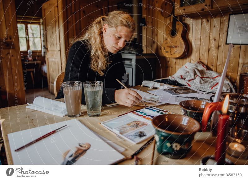 young woman painting with watercolor in rustic hut Young woman Painting (action, artwork) Paintbrush Colour Watercolors motif creatively Hut Quaint Draw