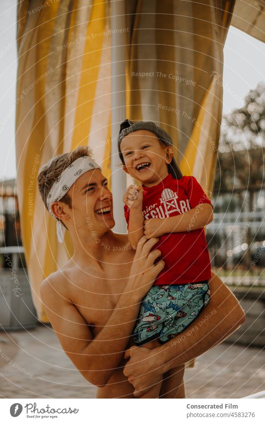 Man tickling little toddler boy at the pool on a sunny day Dad Father Uncle Family Travel Adventure Fatherhood Together Fun Joy Happy Resort Pool Swimming pool