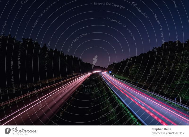 A german Autobahn at night with lighttrails of the fast driving cars in red, wallpaper photo for a high speed concept. autobahn road traffic transportation