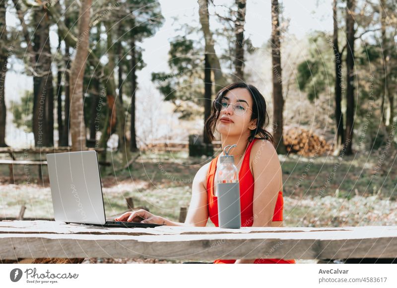 Arab woman doing yoga with online curse outdoors in morning. Copy space images, stretching and doing yoga positions. Sport cloths during a sunny day. Self care athlete