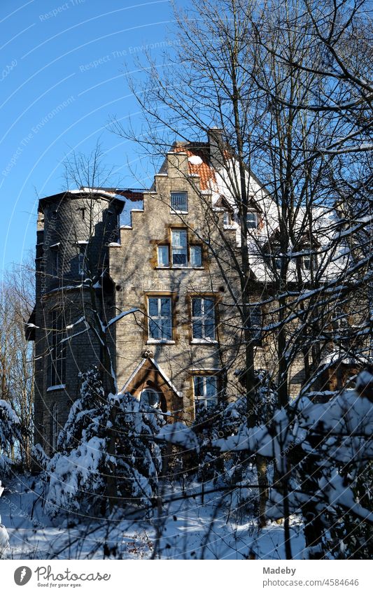 The Old Müller Castle with stepped gable in winter in front of a blue sky in the sunshine in Oerlinghausen near Bielefeld at the Hermannsweg in the Teutoburg Forest in East Westphalia-Lippe