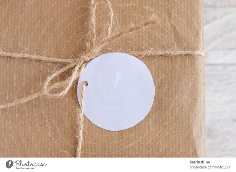 Kraft paper wrapped present with round blank gift tag top view, Mockup mockup kraft beige minimal rope holiday celebration package box card mock up gift box