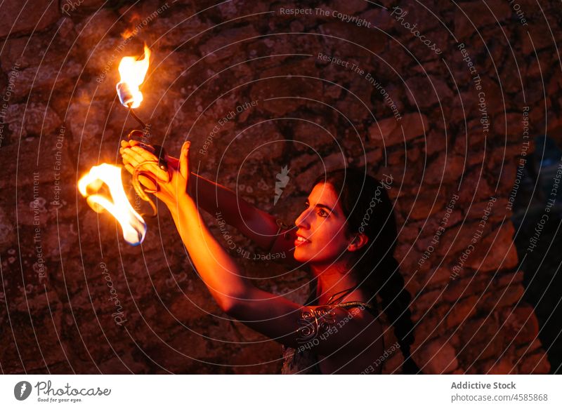 Woman with fire fans at night woman dancer perform entertain show practice talent city skill flame medieval village amusement burn effect bright spark fiery