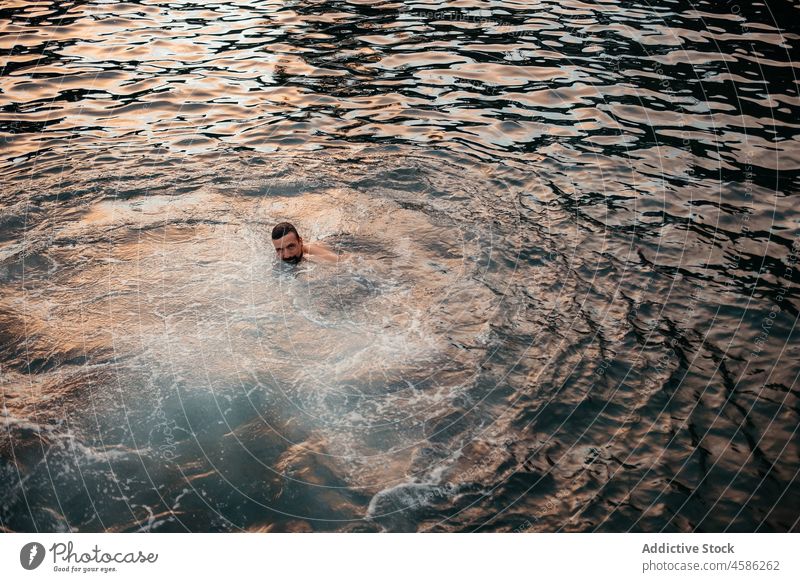 Bearded man swimming in dark water sea aqua recreation travel vacation rest relax male ethnic beard ripple azores sao miguel portugal dark hair shirtless nature