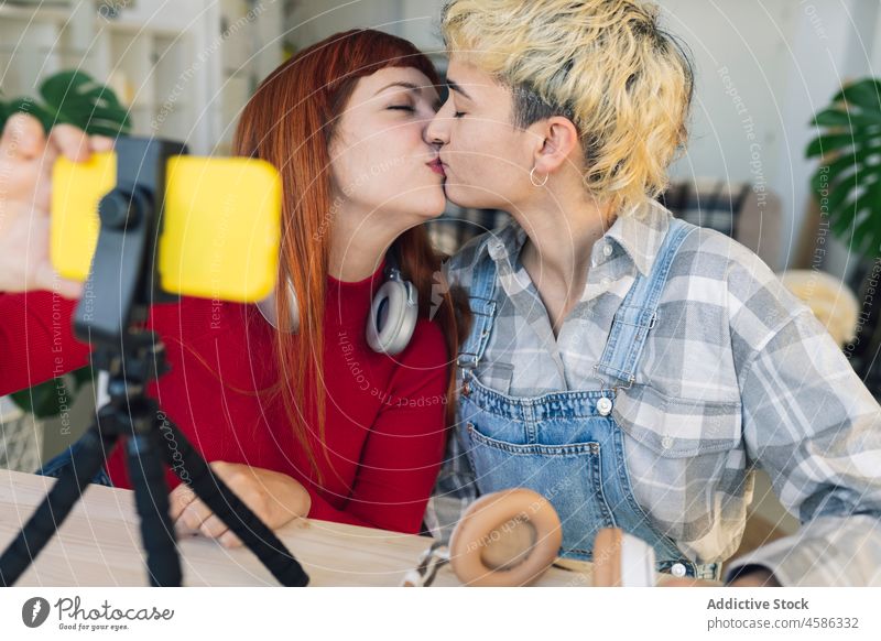 Positive lesbians taking selfie on smartphone women couple self portrait kiss caress homosexual blogger lgbt partner love relationship hobby apartment together