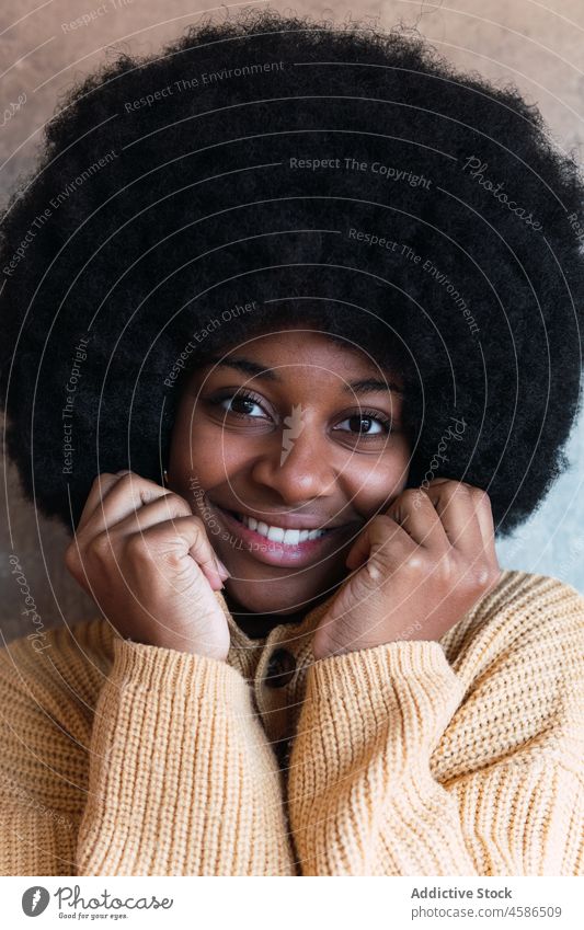 Smiling black woman with closed eyes afro smile cheerful sweater individuality personality happy appearance female african american hairstyle young curly hair
