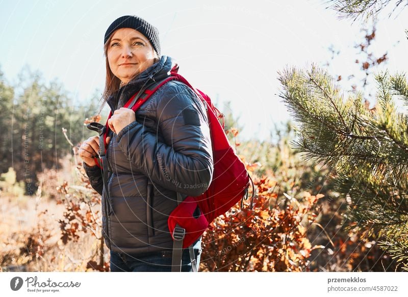 Happy woman enjoying hike on sunny vacation day. Female with backpack walking through forest trip hiking adventure travel summer journey wanderlust hiker