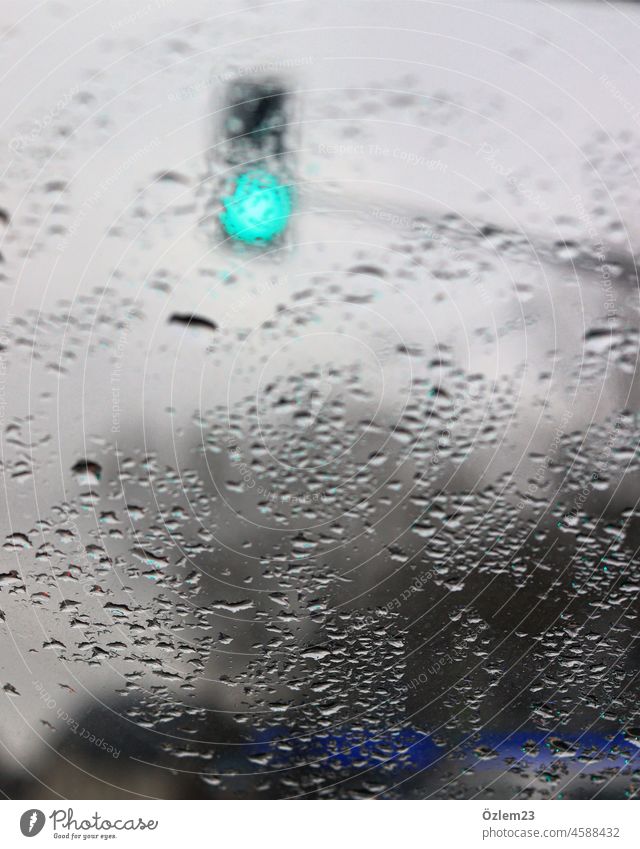 Raindrops on the windshield and a green traffic light raindrops rainy day Motoring car Car Window FRontwheel Traffic light Green Transport In transit Road sign
