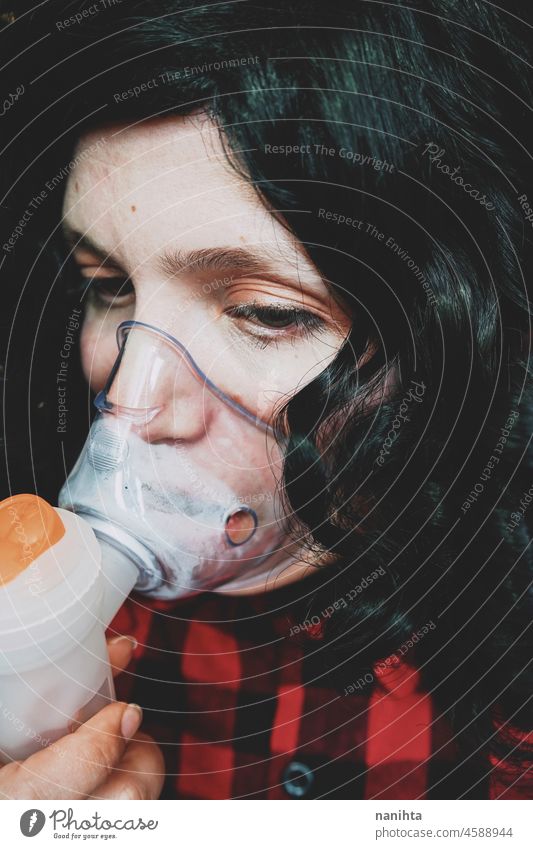 Young woman wearing an oxygen mask medical asthma flu allergy covid coronavirus covid-19 breathe ill illness healthcare young brunette close close up equipment
