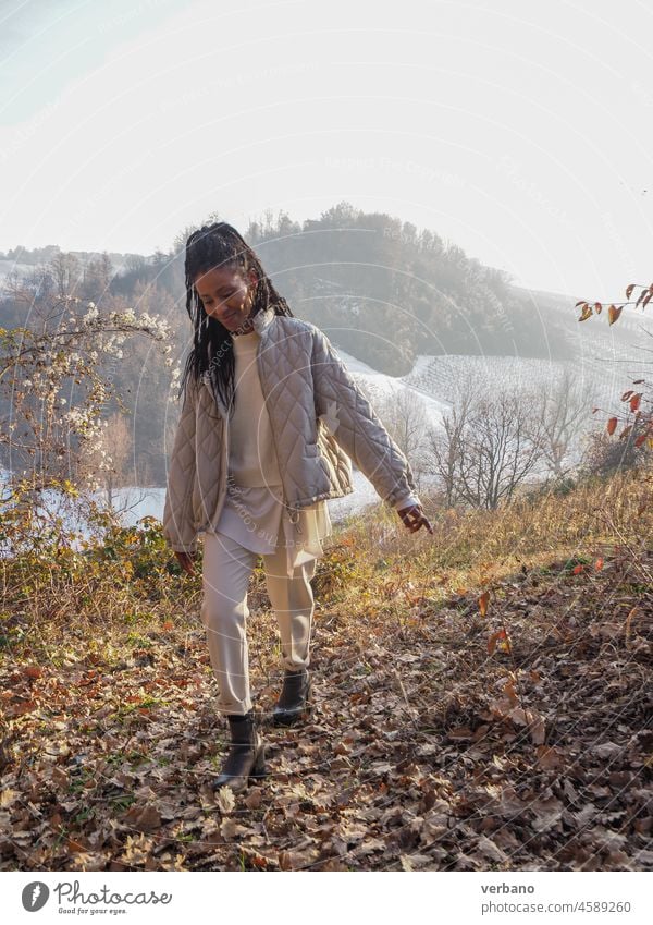 happy young african elegant  woman walking on a mountain landscape dreadlocks black beautiful female cheerful adult happiness portrait girl people lifestyle