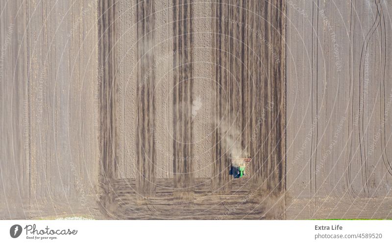 Aerial view of tractor as dragging a seedbed cultivator over agricultural field, farmland Above Across Agricultural Agriculture Agronomy Arable Country