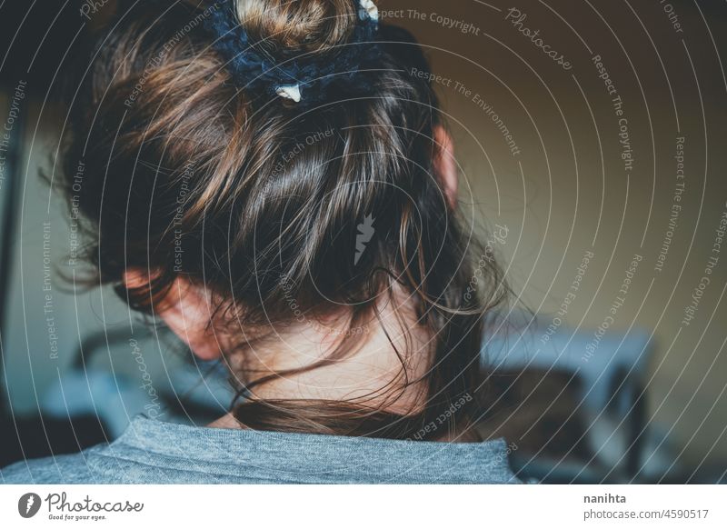 Back view of a comfortly bun hairstyle of a young woman romantic casual home brunette blonde back delicate fragile sensations feel hairband hair band messy hair
