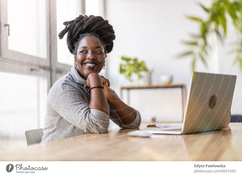 Woman working on laptop in her office black millennials hipster indoors loft window natural adult one attractive successful people confident person beautiful