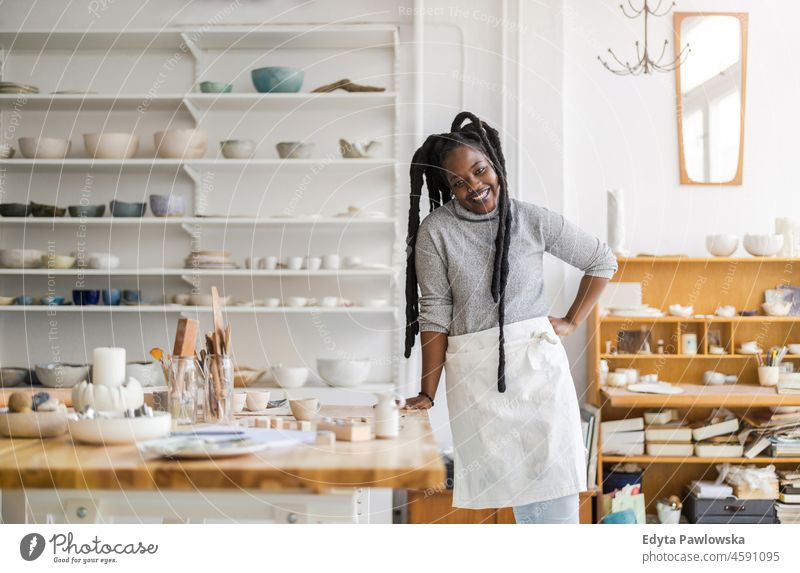 Confident female pottery artist in her art studio black millennials hipster indoors loft window natural adult one attractive successful people confident person