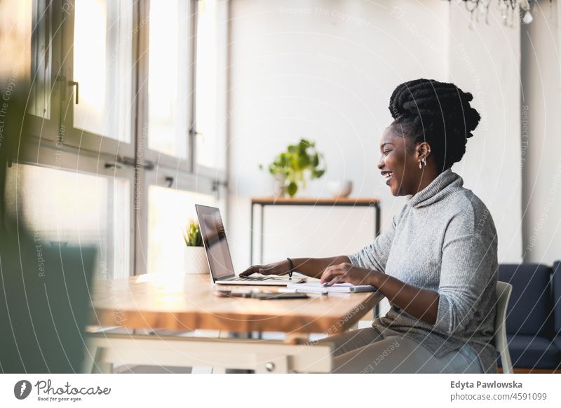 Woman working on laptop in her office black millennials hipster indoors loft window natural adult one attractive successful people confident person beautiful